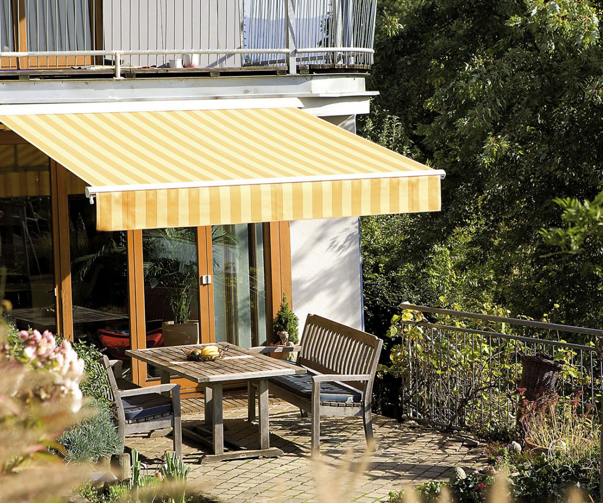 Hülsenmarkise als Sonnenschutz über einer Terrasse am Wohnhaus