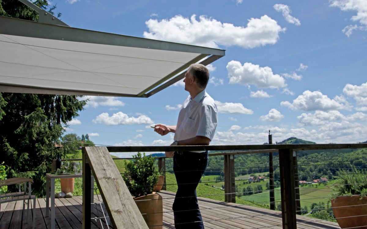 Kunde auf einer Terrasse mit Markise als Sonnenschutz nach fachgerechter Montage