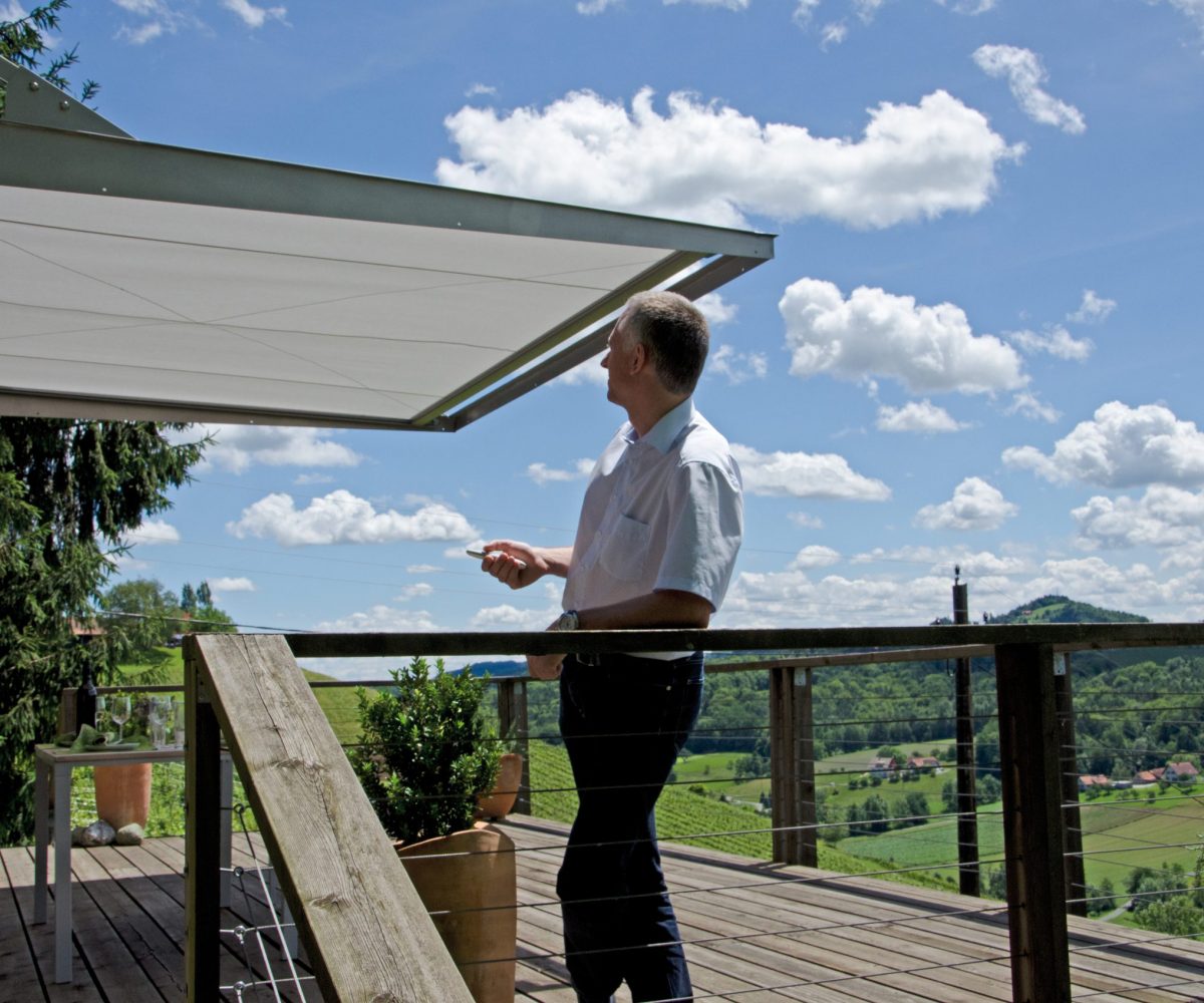 Kunde auf einer Terrasse mit Markise als Sonnenschutz nach fachgerechter Montage